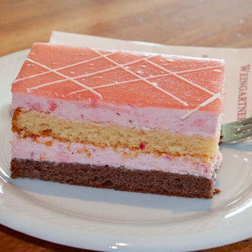 1 Stück Erdbeer Obers Schnitte auf einem weißen Teller